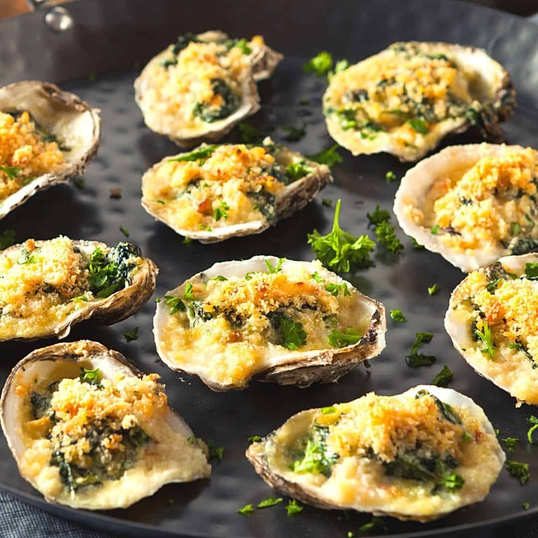 A platter of one bite appetizers including deviled eggs, stuffed mushrooms, and bruschetta with vibrant toppings.