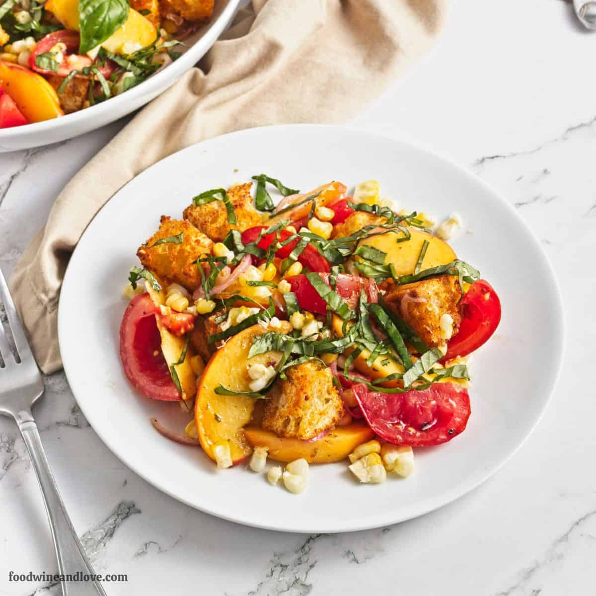 Peach and Corn Panzanella Salad recipe combines juicy peaches, sweet corn, ripe tomatoes, and basil, tossed in a tangy vinaigrette. Sweet peaches, fresh corn, juicy tomatoes, basil, and crispy homemade croutons come together in this vibrant Peach and Corn Panzanella Salad!
